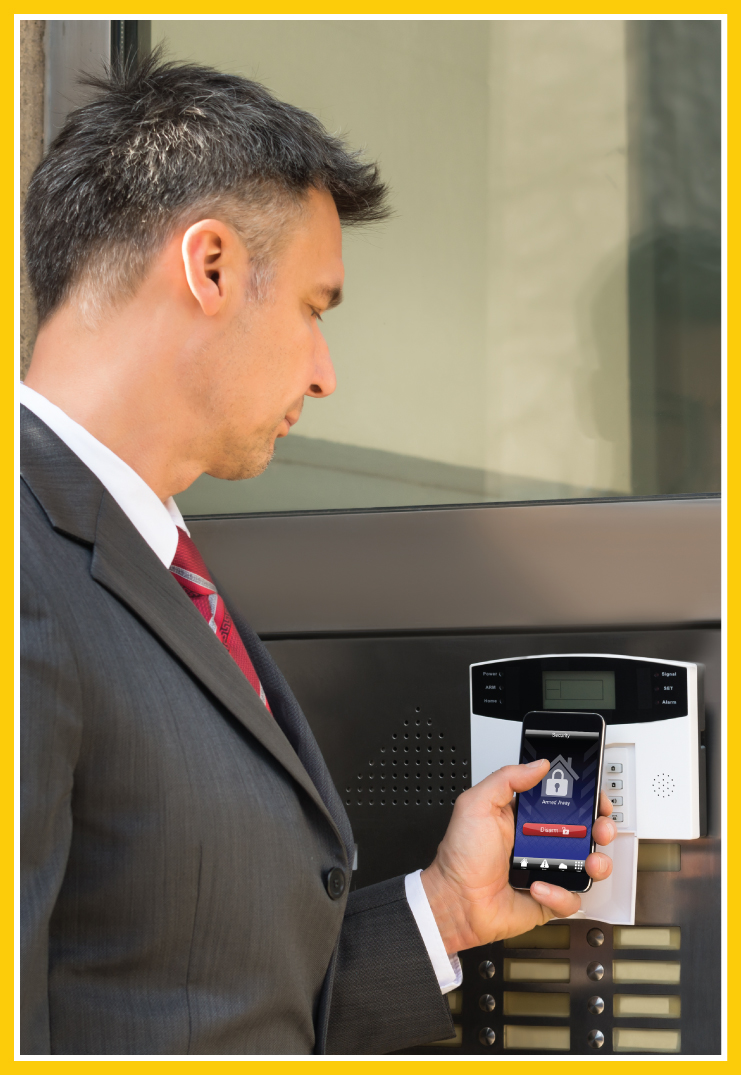 Man in a suit using his phone on a keypad for access control