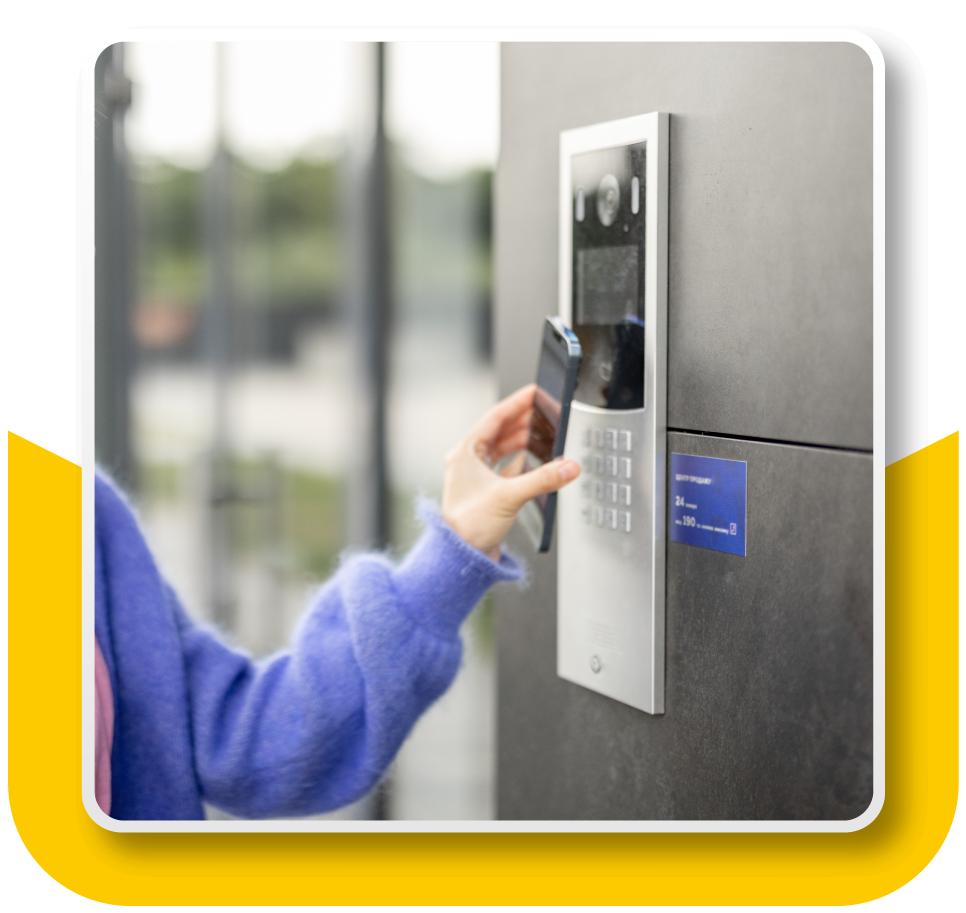 Framed Image: Keyless access control at the front of a hotel or resort building. Person holding their phone up to an access control panel