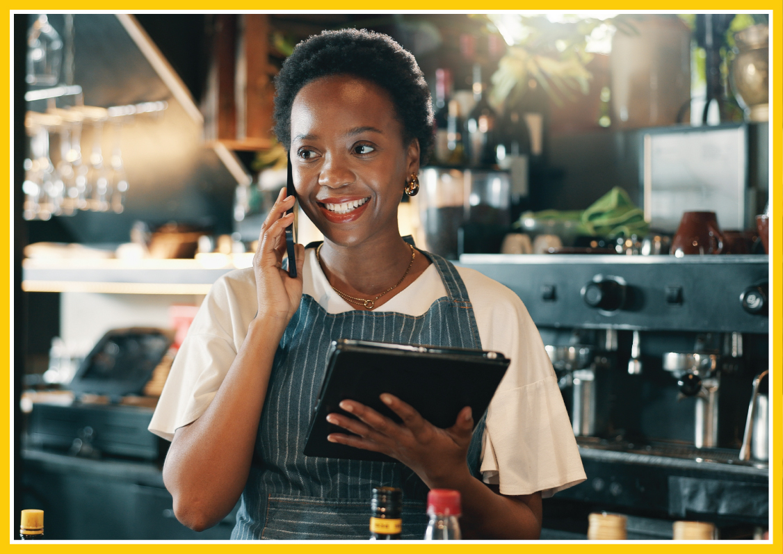 Waitress on the phone with a customer, tablet in her other hand